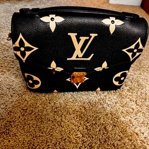 Louis Vuitton
Pochette Metis Bicolor Monogram Empreinte Giant.